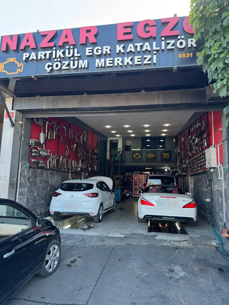 Nazar Egzoz dükkanının önü, tabela ve kanal üzerindeki araçlar